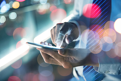 Close up shot of a man holding phone and exploring the up-to-date benefits technology to help employers with attraction, retention about 2022 insights