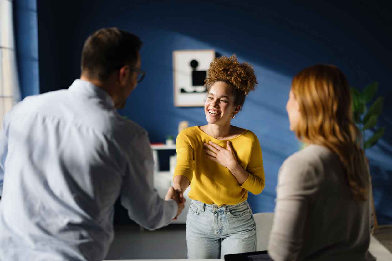 Happy candidate greeting one of the members of human resource team before a job interview in the office.