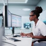 Hospital Doctor Using Spreadsheet For Billing Codes On Desktop